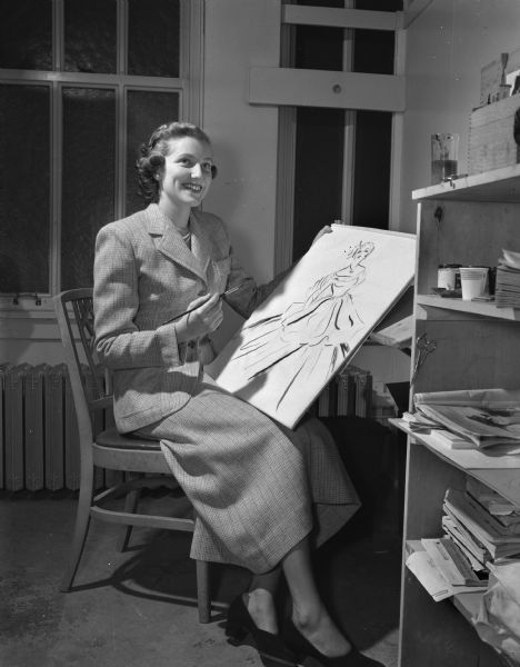 Pattie Neilson, recent art school graduate of the University of Wisconsin, and a fashion illustrator and copy writer for a Madison women's specialty shop, models a spring tweed suit suitable for work.