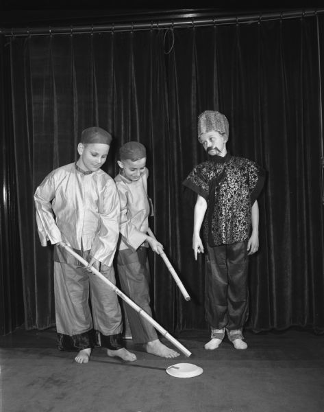 Junior Red Cross variety show. James Stiene and Dick Grahn with sticks, work hard in the variety show's Chinese play under the supervision of Bob Pickarts. Students are from Lowell School. 