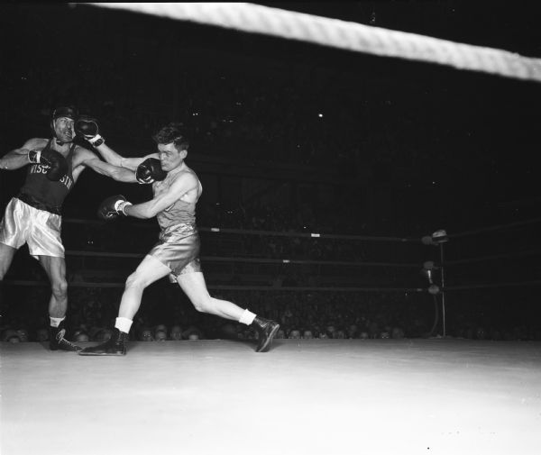 Paul Kotrodimos of the University of Wisconsin in his boxing match against Norm Walker of the University of Idaho.