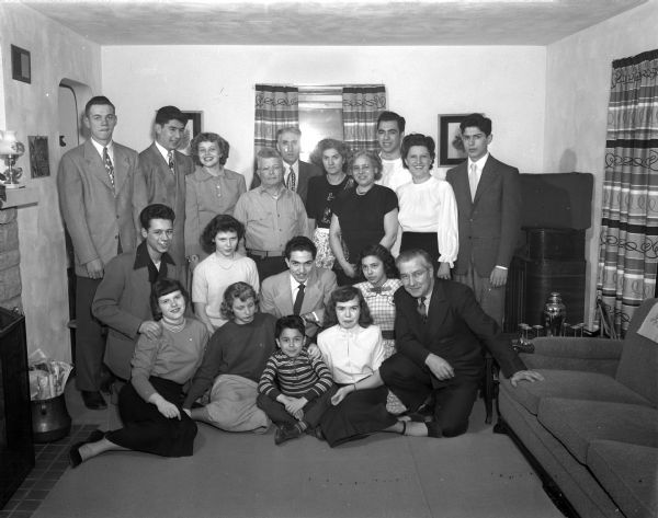 A family portrait with nineteen people in the living room of a residence.