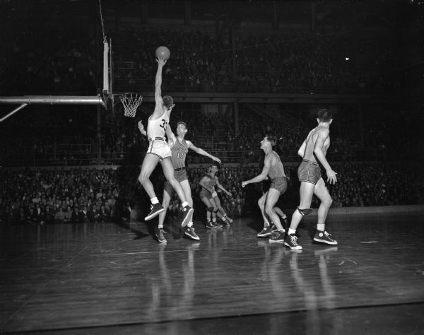 Don Rehfeldt (33), Wisconsin, and Frank Calsheek (11), Iowa, during the Wisconsin vs. Iowa Western Conference basketball game at the Field House.