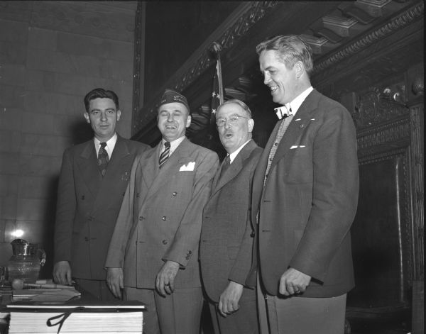 Lyall T. Beggs, former legislator from Madison and presently national commander of the Veterans of Foreign Wars, being escorted to the speaker's rostrum in the state assembly chamber. Pictured from left to right are: Assemblyman William J. Duffy; Beggs; Assembly speaker Alex J. Nicol; and Assemblyman Mark Catlin, Jr.