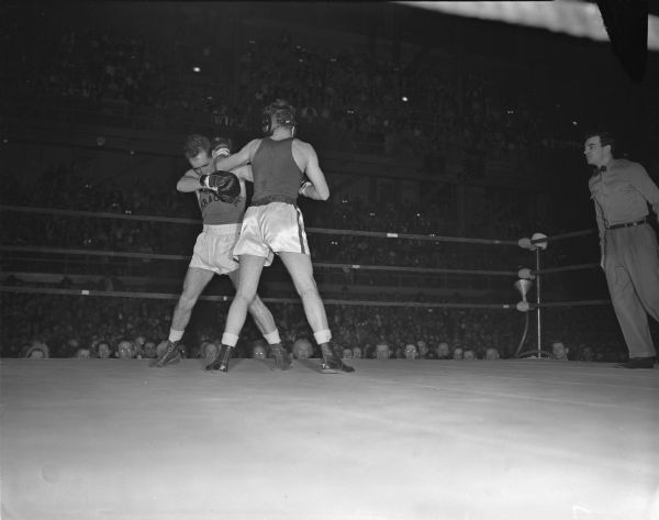 University of Wisconsin boxer, Dick Curran, lands a punch to the head of Syracuse boxer, Jay Wason.
