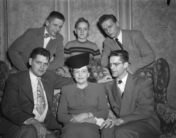 Group portrait of the Meier family at the East Side Women's Club annual mother-son banquet.  Seated on a sofa from the left are: John W. Meier, Mrs. Jack Meier, and Charles R. Meier.  Standing in the back from the left are: Ronald H. Meier, Dean R. Meier, and James E. Meier.
