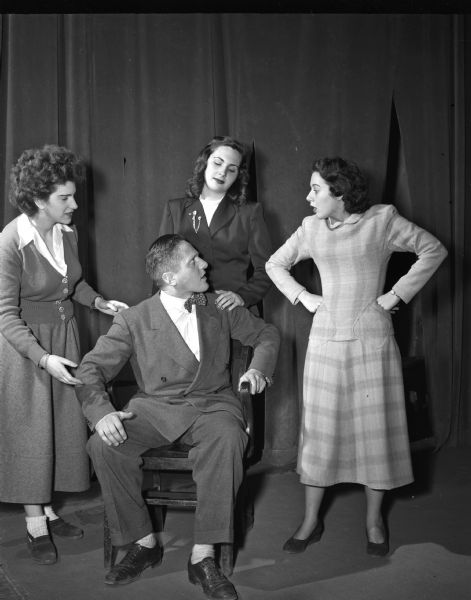 Shown are some of the players rehearsing for "Le Malade Imaginaire", the Moliere comedy which the U.W. department of French and Italian presented at the Wisconsin Union theater. In the center is Prof. Alfred Glauser as Argan, the hypochondriac about whom the plot revolves. Surrounding him (left to right) are Jeanine Volff as Angelique, his daughter; Ann Shoemaker as Beline, his wife, and Dolores Mann as Toinette, the family's maid. Prof. Glauser also directed the play.