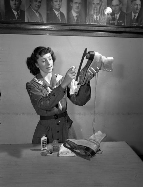 Margaret Brigham, 2814 Lakeland Avenue, is shown giving her ice skates a good cleaning as part of the Girl Scout project on care of property and equipment.