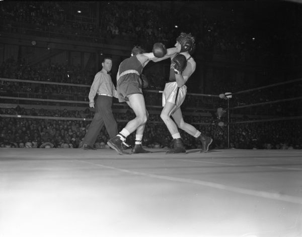 Steve Gremban, University of Wisconsin's NCAA champion, pictured ar right, is shown evading one of the many right punches thrown by Jackie Melson of Washington State University, at left. Gremban lost the match to Melson by a 29-28 score, the first defeat of his boxing career.