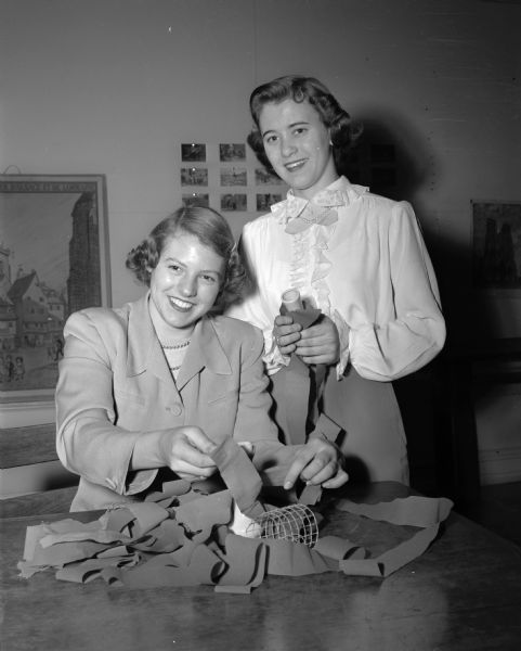 Nancy Fowlkes, left, and Virginia Hammen are shown as they worked on decorations for the Sophomore Shuffle at Wisconsin High School. "With the arrival of spring, a party air dominates most of the high schools."