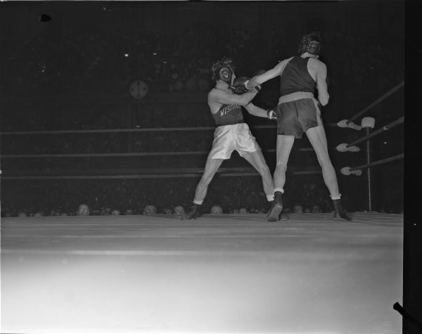 University of Minnesota boxer Dave Mackey (right) lands a left jab to the jaw of Wisconsin's national collegiate champion Steve Gremban in their boxing match at the University of Wisconsin-Madison Field House.