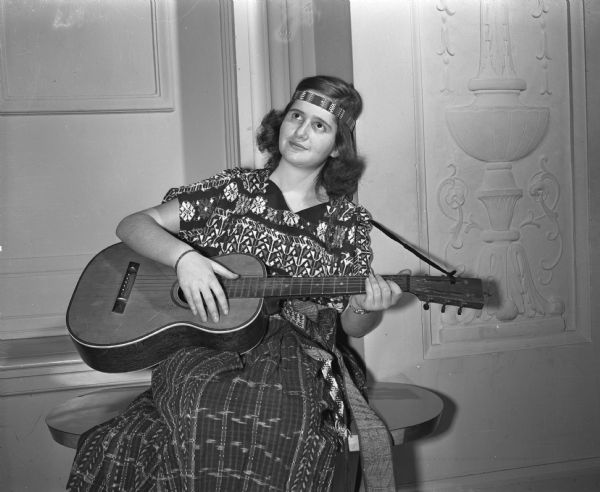 Ruth Lerdau, of Lima, Peru, playing the guitar at the University of Wisconsin's International Club Ball at the Memorial Union.