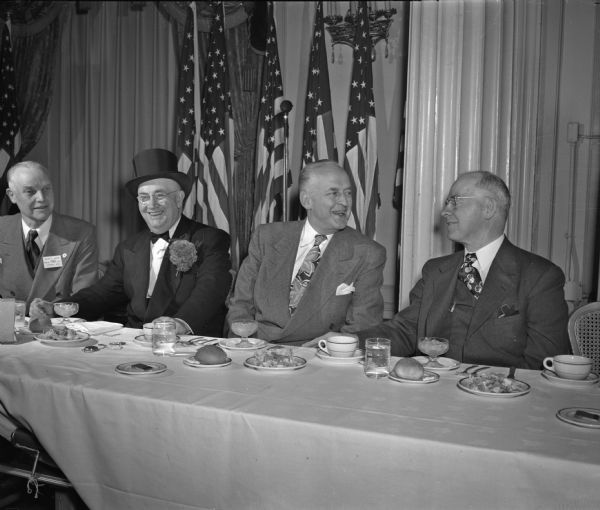 Seated at the speakers' table at the Wisconsin Retail Lumbermen's banquet are (from left to right): Ralph E. Nuzum, Viroqua, president; D. Lee Watts, Madison, vice-president; Gates Ferguson, Chicago; and J.J. Fitzpatrick, Madison, sponsor of the dinner, which honored graduates of the retail lumbermen's training course offered by the University of Wisconsin school of commerce.