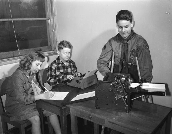 Three older students work on the student newspaper in the orthopedic department at Washington School, 545 West Dayton Street. One of the students is a boy scout.