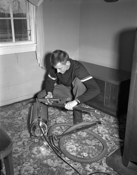 William G. "Bill" Fisher, 733 Copeland Avenue, shares housecleaning tasks by cleaning, oiling and checking the family vacuum cleaner.