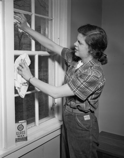 Mrs. William B. (Rachel) Fisher, 733 Copeland Avenue, washing windows in the family home. A new bride, this is her first spring cleaning.