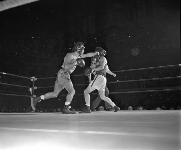 James "Red" Sreenan of the University of Wisconsin boxing team blocks a left jab from Al Tafoya of San Jose State during their boxing match in the fieldhouse.
