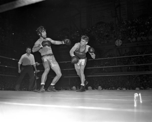 John Lendenski of the University of Wisconsin boxing team has just landed a punch to Pete Franusich of San Jose State during their boxing match in the fieldhouse.
