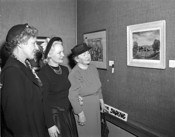 Pictured admiring the water color "Landscape" by Mrs. M.J. (Genevieve) Cass, which was first place winner in water color class of the Madison Art Guild's annual exhibition, are left to right, Mrs. E.B. (Florence) Tomlinson, who placed first in the oils class; Mrs. Ruth Myre, chariman of the Art Guild's tea at which the winners were announced, and Mrs. R.C. Morley, who placed second in the oils class.