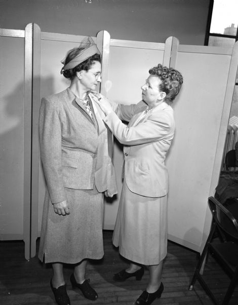 Mrs. Florence Schlobohm, who teaches a class in fur remodeling at the Madison Vocational School, fitting a cape pattern on Mrs. Nathan (Mollie) Sweet, a former furrier.