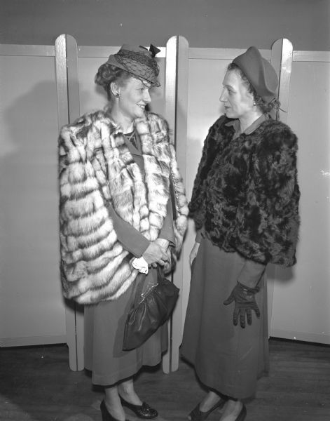 Mrs. David L. (Leta) Williams, left, and Mrs. Claude F. (Louise) Schroeder admire their fur creations at a fur remodeling class at the Madison Vocational School.