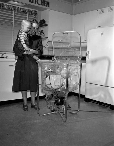Mrs. Robert C. Pittenger and son, Mike, examine a new electric dishwasher at the Madison Home Appliance and Radio Show in the East High School gymnasium.