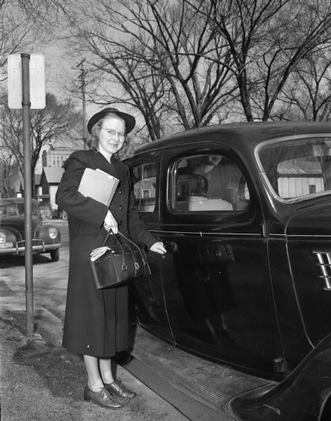 Visiting nurse Esther Sorensen standing at her car ready to start her daily activities.