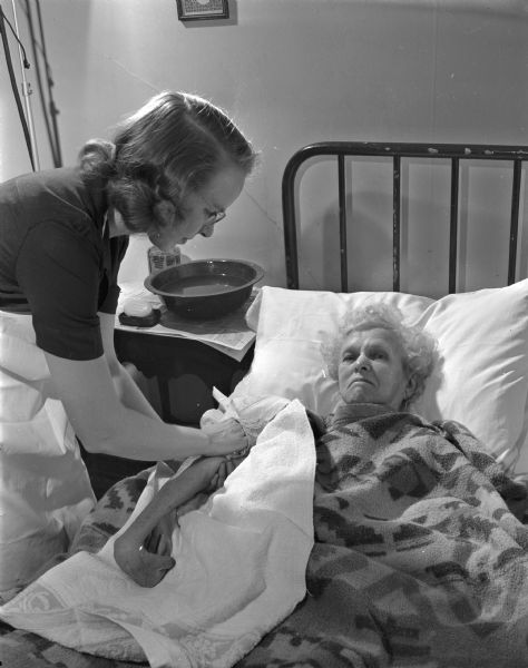 Visiting nurse Esther Sorensen caring for elderly resident Clotilda Contell, who she visits regularly.