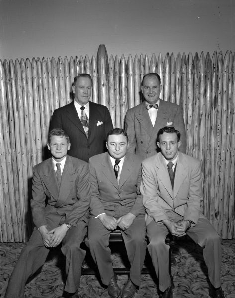 Group portrait of those honored at the University of Wisconsin annual boxing banquet. Front row, left to right: co-captain Steve Gremban; honored guest Omar Crocker, former reknowned Badger boxer; co-captain Dwaine Dickinson. Back row: assistant coach Vern Woodward; and coach Johnny Walsh.