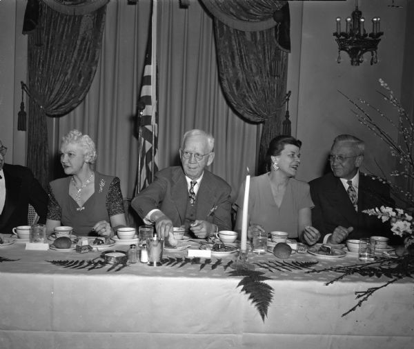 People sitting at the speakers' table at the Mississippi Valley Historical Association dinner at the Hotel Loraine. From left are Mrs. Oscar Rennebohm, wife of the Wisconsin governor; Emeritus Dean George C. Sellery of the University of Wisconsin; Mrs. Dwight L. Dumond, wife of the association president; and Wisconsin governor Oscar Rennebohm.