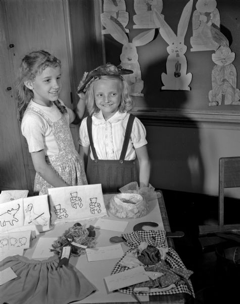 At left, Penny Brown, 201 North Broom Street, and her doll clothing and hat exhibit. At right, Karen Peterson, 212 Marion Street, models one of the hats.