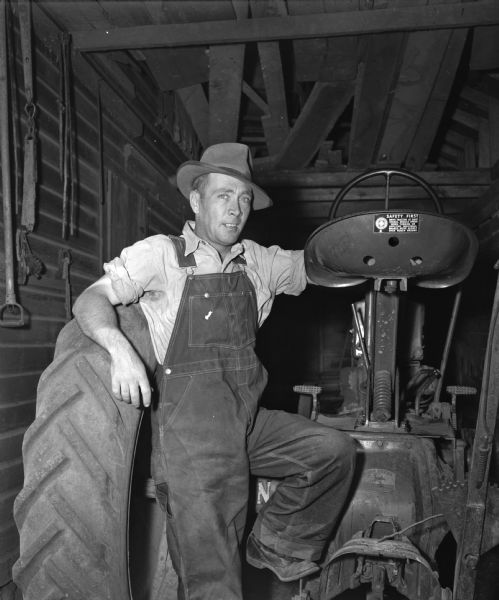 John Gates, a farmer near La Valle, standing beside his tractor. He was once a saxophone player with a dance orchestra.