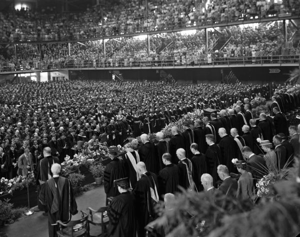One of six photographs used to make a panorama of the University of Wisconsin centennial commencement ceremony at the University of Wisconsin-Madison Field House. 3,400 young men and women received their degrees at what was the university's largest graduating class.