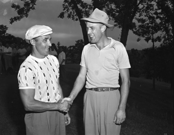 Men's city golf champions, left, Steve Caravello, 1949 champion, and right, Harland Reich, 1948 champion shaking hands. The tournament was at Blackhawk Country Club.