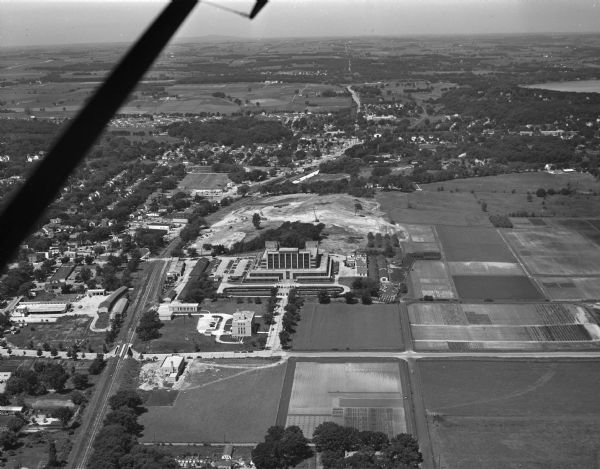 Aerial photograph looking west across Walnut Street at Forest Products Laboratory and the construction site of the Veterans Administration Hospital.  Railroad tracks run along the left side of the photograph.