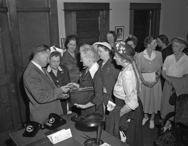 Police Chief Bruce Weatherly meeting with members of the National Federation of Republican Women's Clubs who were touring government offices while in Madison for a meeting. Mrs. John W. Hunt, Oswego, Illinois, secretary of the federation, is shown displaying her deputy sheriff's badge from Kendall County, Illinois.