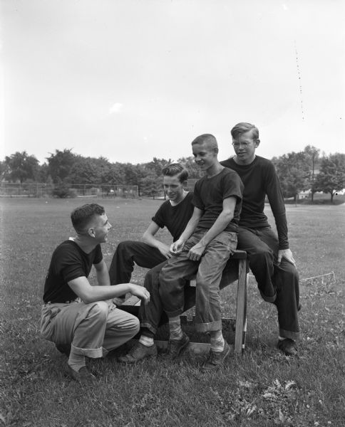 Four Madison boys who play for a baseball team in the senior league talk over the season. From left are: Jack Blodgett, Jim Miller, Bob Bakken, and Duane Moen.