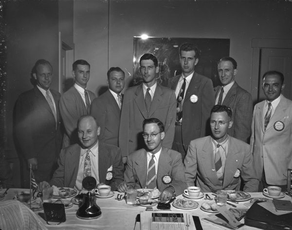 The newly elected officers of the Madison Exchange Club gather around a table at a meeting at the Capital Hotel. Seated, from left, are: Corwin E. Shell, president; Clarence M. Beebe, past president; and John White, secretary. Standing, from left, are: Clifford W. Pauls, board member; Charles H. Haynie, board member; Don J. Bergenske, vice-president; Thomas H. Flad, board member; Lyman R. Frazier, treasurer; Robert E. Trapp, board member; and Theodore J. Bast, board member.