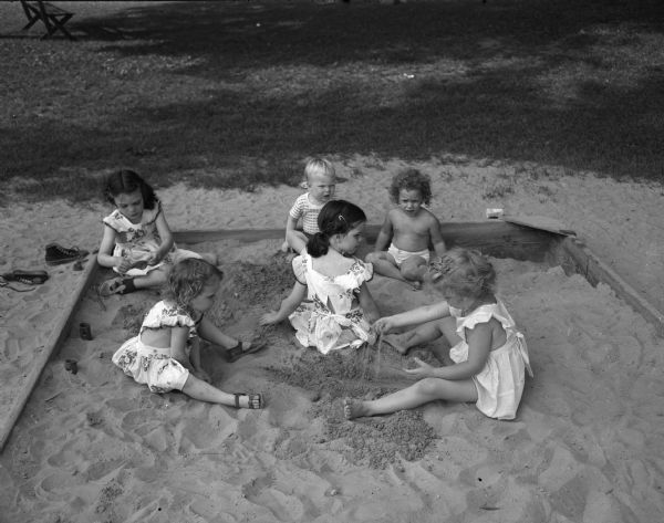 Six children playing in a sand box at Vilas Park.