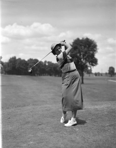 Marian Callahn swinging a golf club at Maple Bluff Country Club.  She was a leader after the qualifying round of the Wisconsin Women's Golf Association tournament and is a past tournament champion.