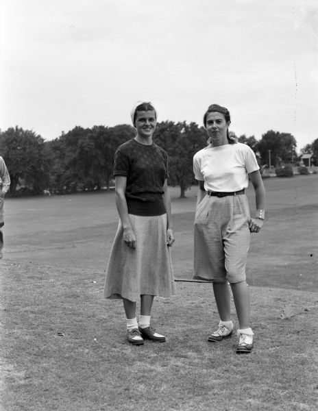 Mrs. Mary McMillin of Green Bay and Mary Louise Kral of Shawano, who will pair off in the semi-final round of the Wisconsin Women's Golf Association Tournament at the Maple Bluff Country Club, standing beside each other on the course.