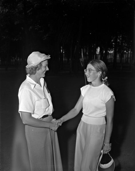 Mrs. John Clauder, left, and Mary Louise Kral shaking hands after their championship round of the Wisconsin Women's Golf Association Tournament at the Maple Bluff Country Club. Mrs. Clauder won the championship on the thirty-fifth hole of their match.