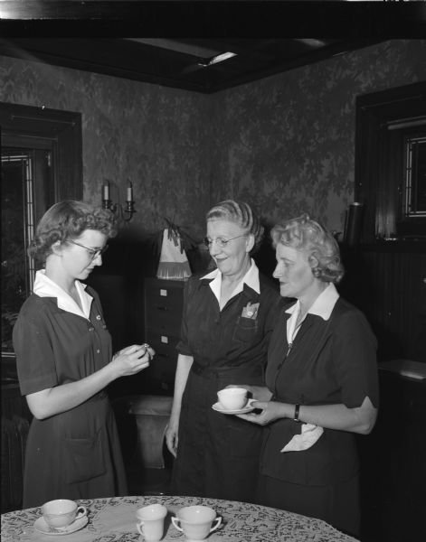 Ethel Bohon, center, and Corinne Mennes, right, receive American Red Cross nurses' badges in recognition for their service. Presenting the award, at left, is Ellen Svoboda, enrollment chairman for the Red Cross Nursing service.