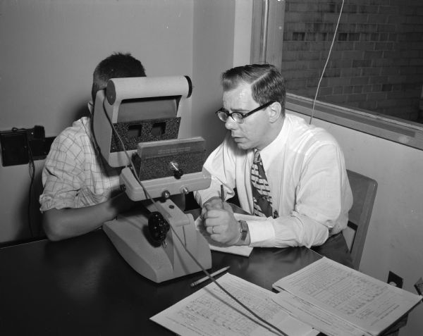 University of Wisconsin summer reading clinic. Jack Ackerman, a teacher from Manitowoc, giving a vision screening test using telebinoculars.