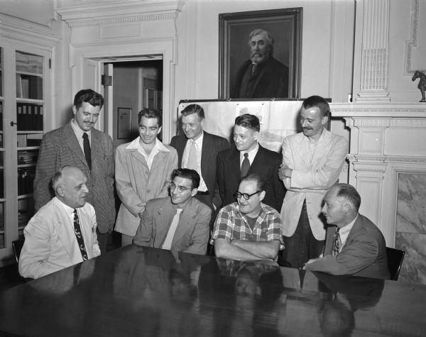 Madison and University of Wisconsin artists carried off the major share of the prizes and awards in the 1949 Gimbel Brothers art competition.  Seated, left to right: President E.B. Fred with artists Santos Zingale, Marshall Glasier and Aaron Bohrod. Standing, left to right are: Dean Meeker, Donald Anderson, James Watrous, Alfred Sessler and John Wilde.