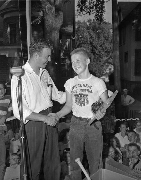 Pierre Slightam (right), winner of the 11th annual Madison Soap Box Derby, is congratulated by Warren Jollymore, director of the <i>Wisconsin State Journal</i> sponsored event. Slightam, the son of Mr. and Mrs. Francis (Marjorie) Slightam, 427 West Wilson Street, will participate in the national classic at Akron, Ohio, as a representative of Madison.