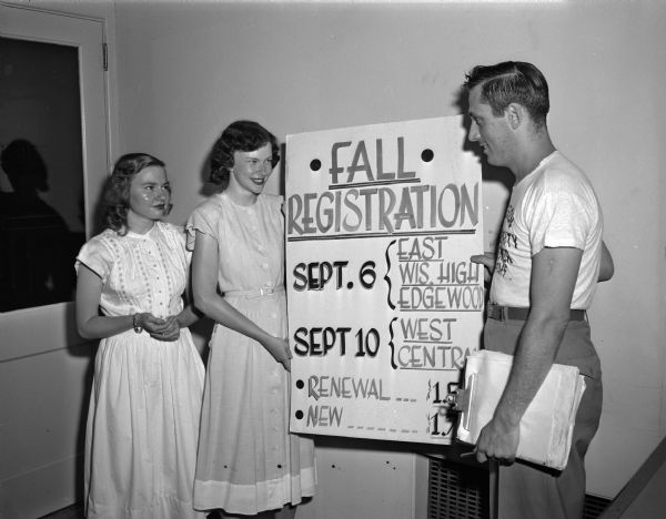 Two teenage girls and an adviser hold a registration poster for LOFT fall membership. LOFT is a teenage youth center and stands for "Lots of Fun Times". Left to right: Pat Haugen and Nancy Mockett, co-chairment of the registration committee; and Erwin "Ace" Karp, LOFT advisor.