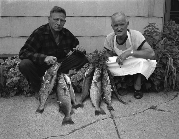 Carl A. "Cully" Kessenich (left), and Carl J. "Cully" Bach display seven walleyes caught in Lake Mendota. A third party to the fishing outing was Carl "Cully" Malec.