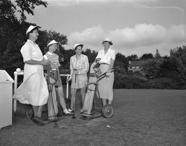 A group of women golfers participate in the Nakoma Golf Club Women's Organization Guest Day. From left to right, the foursome is comprised of: Mrs. Irving B. (Violet) Johnson, 4153 Mandan Crescent, and Mrs. Eddie (Jean) Foye, 606 Briar Hill Road, Nakoma members, and their two guests from Maple Bluff Golf club, Mrs. Ivan (?) Donaghey, 1311 Morrison Street, and Mrs. Paul E. (Edith) Nystrom, 360 Kensington Drive.