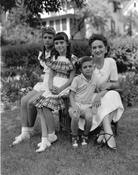Daughters of Mrs. Pearl E. Trummer are visiting during the University of Wisconsin summer session. They are ten-year-old Heidi (left) and her sister, Mrs. Booth Chilcott of St. Louis, shown with her two children, Karen Sue and Booth, Jr.
