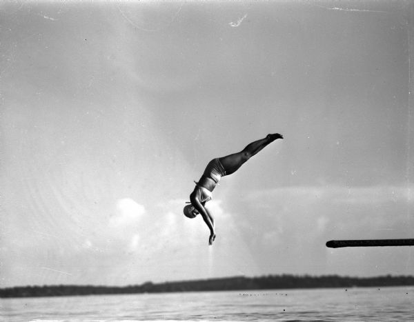 Helen Wear, representing Maple bluff, takes part in the diving competition at the annual Madison city swimming meet held at B.B. Clark beach.  Helen was one of the stars of the swim meet, winning the backstroke and taking second places in the free style and diving competitions.