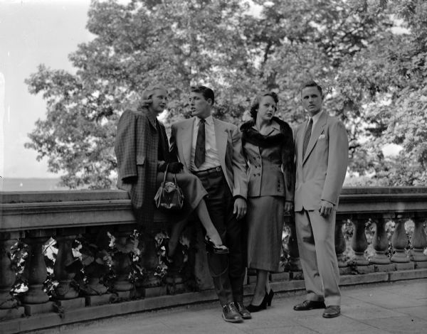Two couples model clothes at the WSGA style show outdoors at Memorial Union. Left to right are: Nancy Olmstead, Oshkosh; Karl Keim, Dearborn, Michigan; Gayle Petty, Chicago, Illinois, and John McCutcheon, St. Louis, Missouri.
